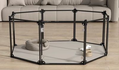 Indoor pet playpen with a pet bed, water bowl, and toy on wooden floor in living room